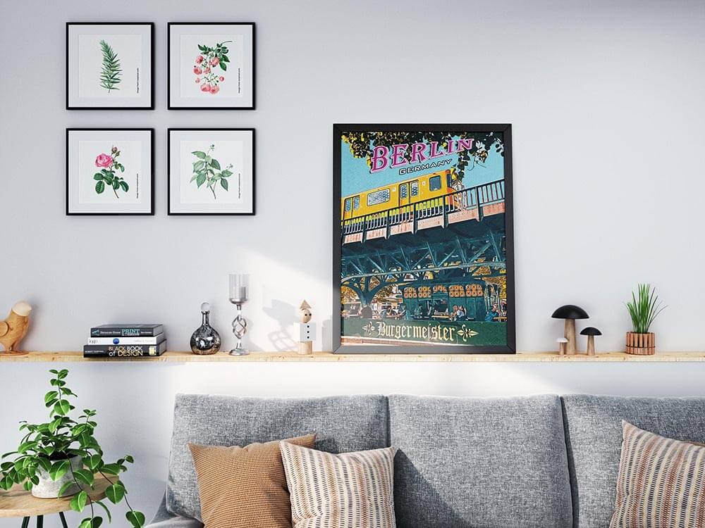 Berlin Burgermeister poster on a wooden shelf above a grey sofa next to a botanical gallery wall.