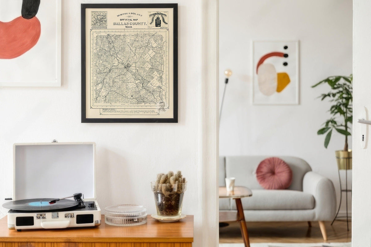 Black framed vintage Dallas County map hanging above a record player in a bright mid century room