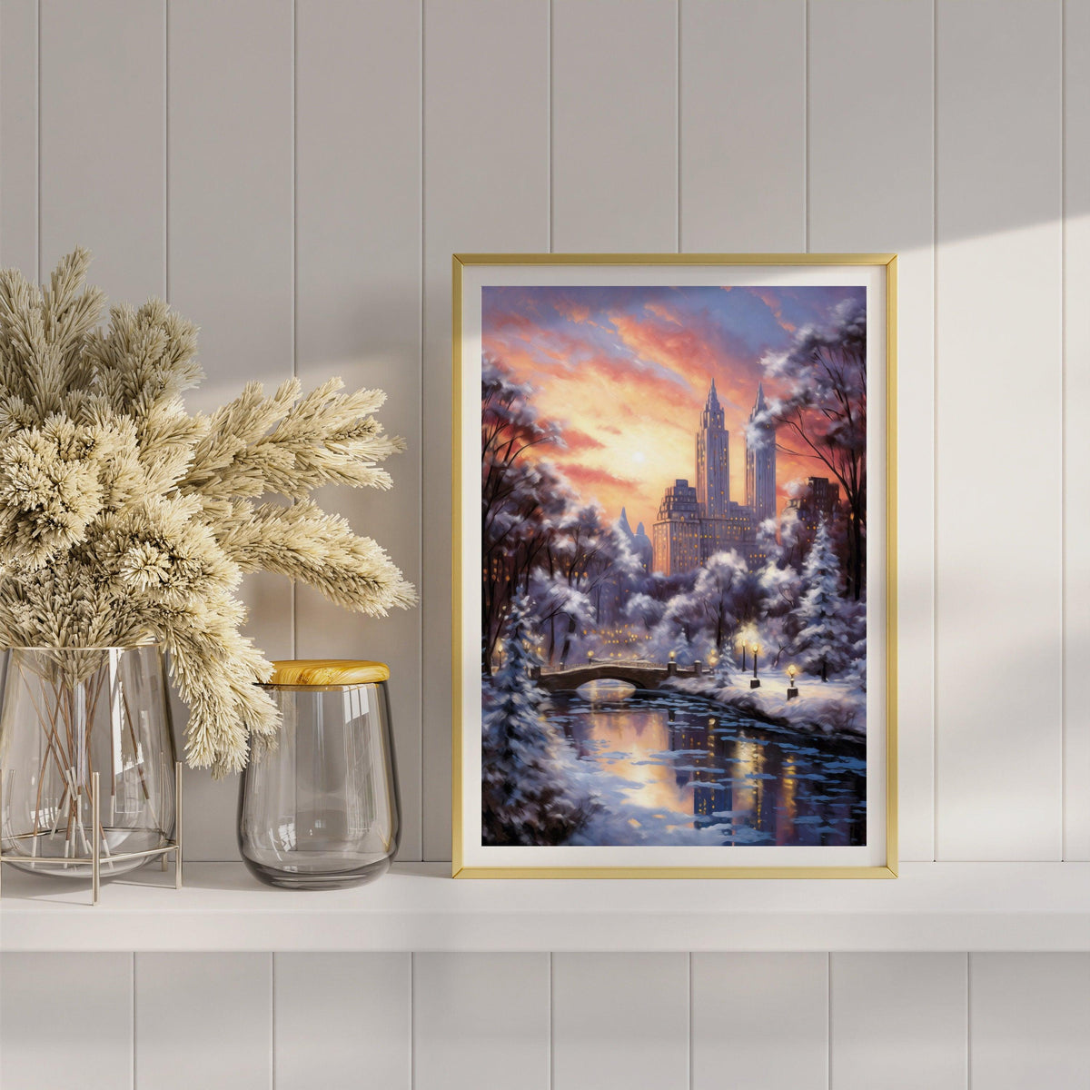 Central Park winter sunset poster in a gold frame leaning on a white shelf with dried flowers